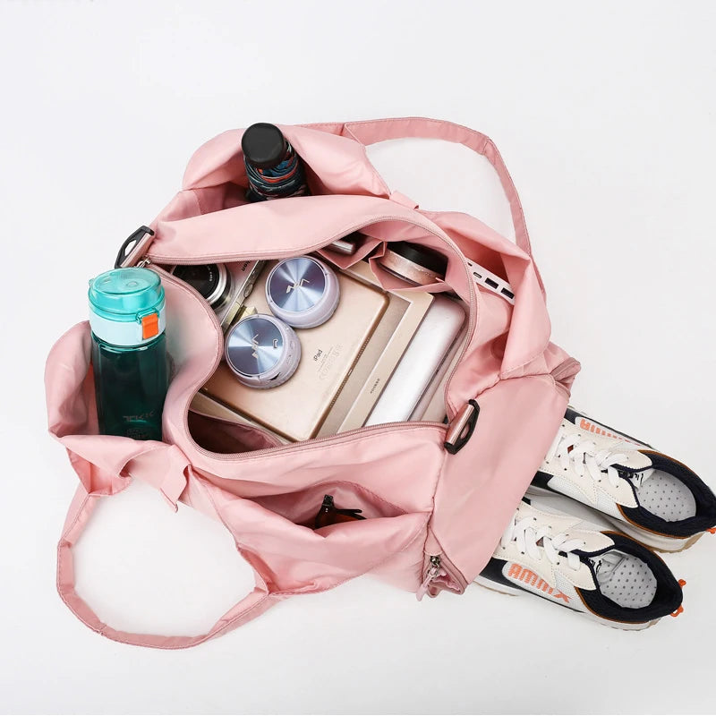 Pink backpack with items including a water bottle, sunglasses, and a notebook on a white background