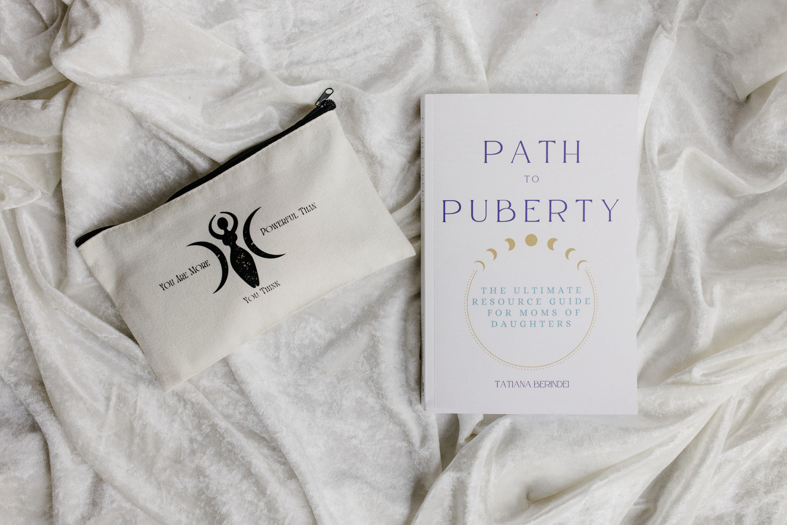 Book titled 'Path to Puberty' and a pouch on a textured white surface
