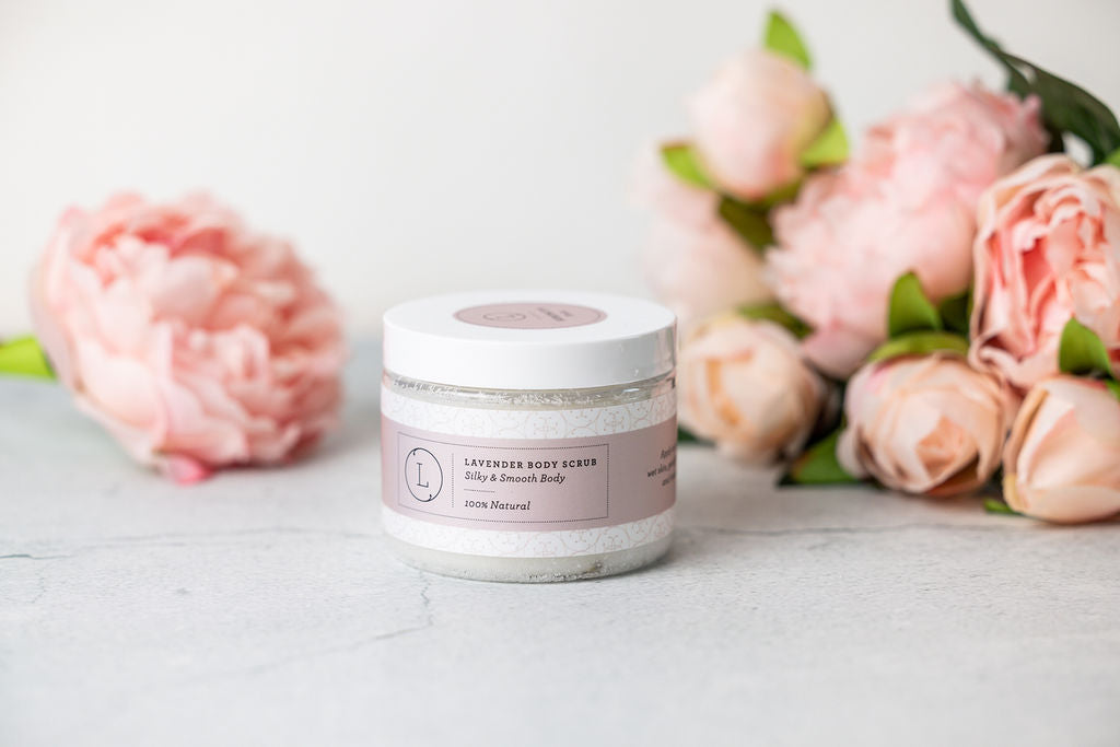Jar of lavender body scrub with pink flowers on a light surface velvet bloom beauty and wellness